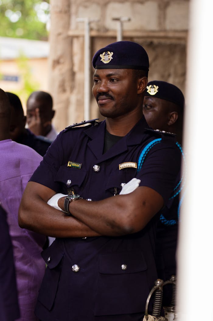Police officer indoors in uniform confidently attending an event or gathering.