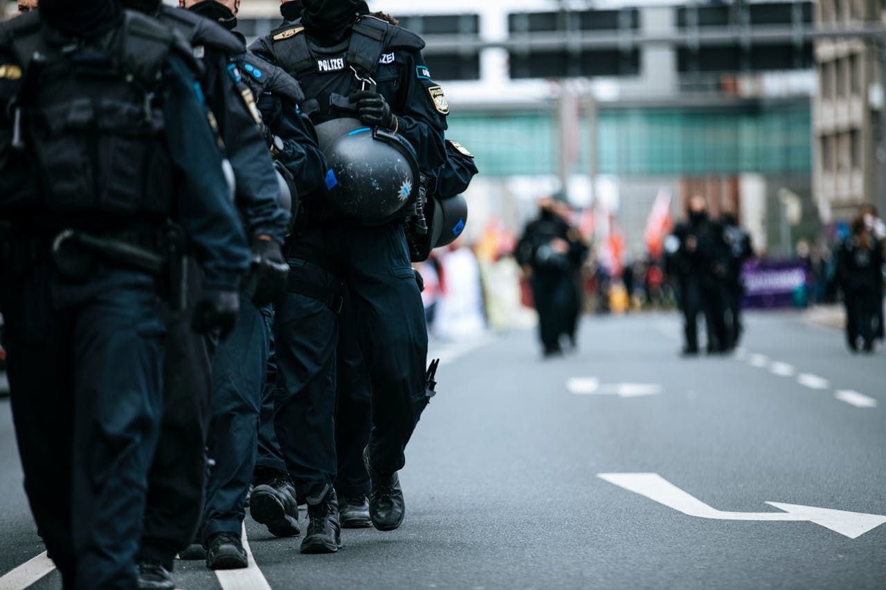 A line of police officers in uniform marching during a city protest, showcasing solidarity.